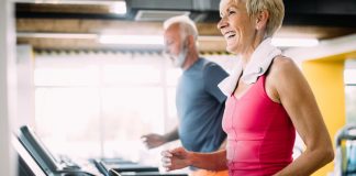 Senior man and woman exercising on treadmills